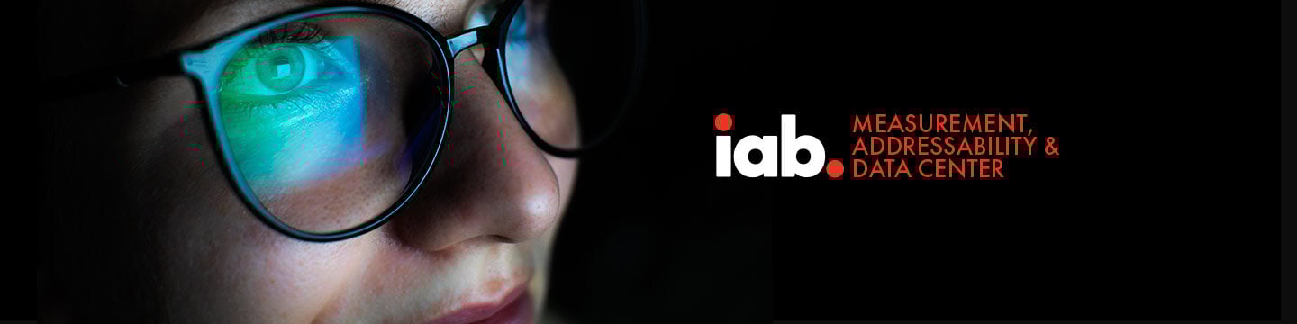 Person wearing glasses with a screen reflecting on the lenses