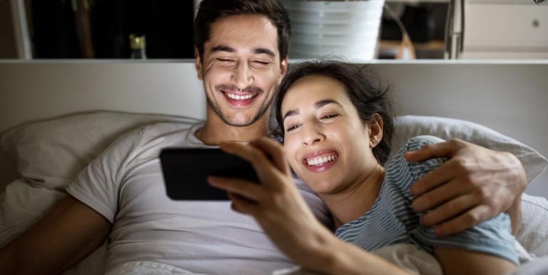 Two people at home watching video together on a phone